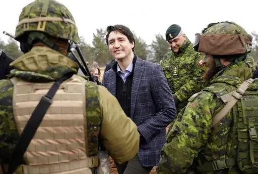 Canadian Prime Minister Justin Trudeau smiles while speaking to Canadian troops during his visit to Adazi Military base in Kadaga, Latvia, on March. 8, 2022. (AP Photo/Roman Koksarov, File)