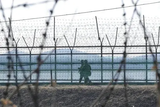 South Korean army soldiers patrol along the barbed-wire fence in Paju, South Korea, near the border with North Korea, Thursday, Feb. 16, 2023. South Korea called North Korea "our enemy" in its biennial defense document published Thursday, reviving the label for its rival for the first time in six years, as tensions worsen between the two. (AP Photo/Ahn Young-joon)