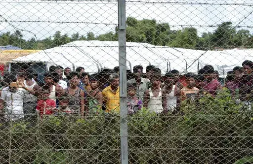 Rohingya refugees gather near a fence during a government organized media tour, to a no-man's land between Myanmar and Bangladesh, near Taungpyolatyar village, Maung Daw, northern Rakhine State, Myanmar, June 29, 2018. An international case accusing Myanmar of genocide against the Rohingya ethnic minority returns to the United Nations' highest court Monday, Feb. 21, 2022, amid questions over whether the country's military rulers should even be allowed to represent the Southeast Asian nation. (AP
