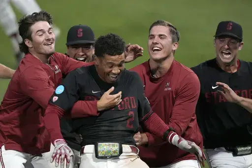 Stanford's Drew Bowser (2) celebrates with teammates after hitting a single to score the winning run against Texas in the ninth inning of an NCAA college baseball tournament super regional game in Stanford, Calif., Monday, June 12, 2023. Stanford won 7-6. (AP Photo/Tony Avelar)