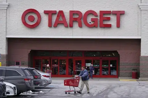 A shopper wheels a cart through the parking lot after making a purchase at the Target store, Monday, Feb. 27, 2023, in Salem, N.H. Target is recalling almost 5 million candles over laceration and burn hazards, according to a Thursday notice published by the U.S. Consumer Product Safety Commission.(AP Photo/Charles Krupa, File)
