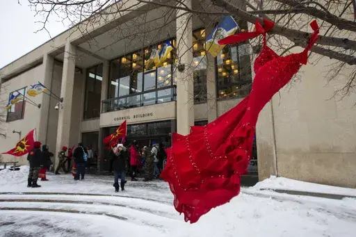 A red dress hangs on a tree in the courtyard at Winnipeg City Hall during a rally, Thursday, Dec. 15, 2022, in Winnipeg, Manitoba, to call on the city to cease dumping operations at Brady landfill and conduct a search for the remains of missing and murdered indigenous women believed to be buried there. Friday, May 5, 2023, marks Missing and Murdered Indigenous Peoples Awareness Day, a solemn day meant to draw more attention to the disproportionate number of Indigenous people who have vanished or