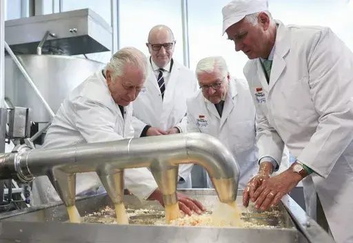 Britain's King Charles III, Dietmar Woidke, prime minister of Brandenburg, and German President Frank-Walter Steinmeier, from left, visit a cheese dairy in the Brodowin eco-village on the second day of the royal tour of Germany, Thursday, March 20, 2023. (Jens Buettner/DPA via AP, Pool)