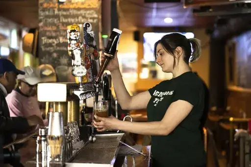 A bartender pours a beer at McMenamin's Tavern in Philadelphia, Thursday, Feb. 9, 2023. Despite having great soft skills, workers with a history of food service work may be overlooked as not having relevant experience when it comes to other careers. These workers, however, often have transferable skills that make for excellent employees, particularly in the fast-paced tech environment.(AP Photo/Matt Rourke, File)