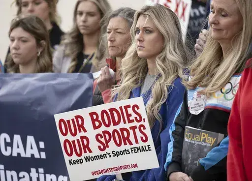 Former University of Kentucky swimmer Riley Gaines, second from right, stands during a rally on Thursday, Jan. 12, 2023, outside of the NCAA Convention in San Antonio. Gaines was among more than a dozen college athletes who filed a lawsuit against the NCAA on Thursday, March 14, 2023, accusing it of violating their Title IX rights by allowing Lia Thomas to compete at national championships in 2022. (AP Photo/Darren Abate, File)