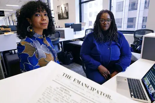 Amber Payne, left, and Deborah Douglas co-editors-in-chief of the new online publication of "The Emancipator" pose at their office inside the Boston Globe, Wednesday, Feb. 2, 2022, in Boston. Boston University's Center for Antiracist Research and The Boston Globe's Opinion team are collaborating to resurrect and reimagine The Emancipator, the first abolitionist newspaper in the United States, which was founded more than 200 years ago. The new incarnation of The Emancipator will explore ways to r