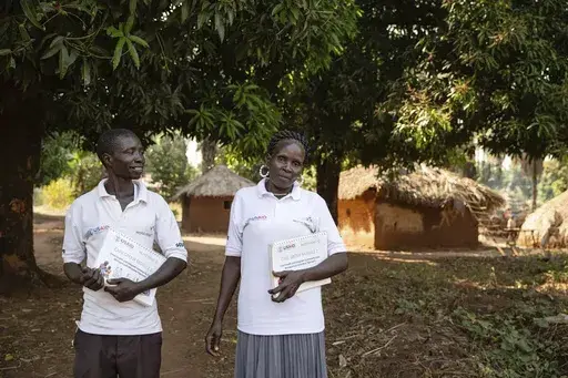 This photo provided by World Relief shows care group volunteers Neimate Mustafa and John Simon Mbiliwele, who provide community health education, visiting a homestead in January 2022, in Maridi, South Sudan. (Esther Mbabazi/World Relief via AP)
