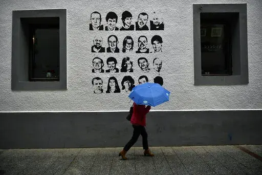 A woman shelters from the rain under an umbrella, while walking past a wall painted with portraits of prisoners of the Basque separatist armed group ETA, in the small village of Hernani, northern Spain, May 2, 2018. The United States is poised to remove five extremist groups, all believed to be defunct, from its list of foreign terrorist organizations. Several of these groups once posed significant threats, killing hundreds if not thousands of people across Asia, Europe and the Middle East. The 