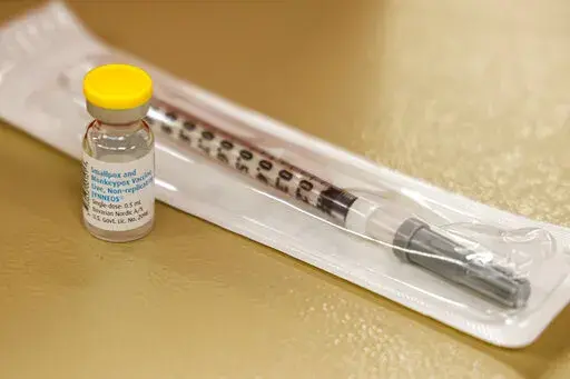 A vial containing the monkeypox vaccine and a syringe is set on the table at a vaccination clinic run by the Mecklenburg County Public Health Department in Charlotte, N.C., Saturday, Aug. 20, 2022. At-risk people who received just one dose of the monkeypox vaccine appeared to be significantly less likely to get sick from the virus, public health officials announced Wednesday, even as they urged a second dose for full protection. (AP Photo/Nell Redmond, File)