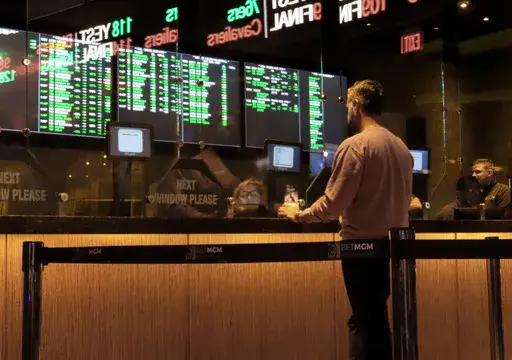 A customer makes a sports bet at the Borgata casino in Atlantic City N.J. on March 17, 2022 just before the March Madness NCAA college basketball tournament began. As March Madness gets underway, more people than ever now can legally bet on sports. A total of 38 states and the District of Columbia now allow some form of sports betting. (AP Photo/Wayne Parry, File)