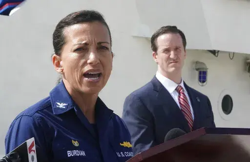 U.S. Coast Guard Captain Jo-Ann Burdian, foreground, speaks along with Homeland Security Investigations Special Agent in Charge in Miami Anthony Salisbury, rear, during a news conference, Thursday, Jan. 27, 2022, at Coast Guard Sector Miami in Miami Beach, Fla. The Coast Guard says it has found four more bodies in its search for dozens of migrants lost at sea off Florida, for a total of five bodies. The maritime security agency said Thursday that it also plans to call off its active search for s