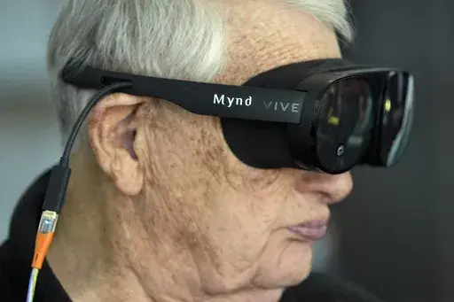 Retired Army Col. Farrell Patrick, 91, wears a Mynd Immersive virtual reality headset at John Knox Village, Wednesday, Jan. 31, 2024, in Pompano Beach, Fla. John Knox Village was one of 17 senior communities around the country that participated in a recently published Stanford University study that found that large majorities of 245 participants between 65- and 103-years-old enjoyed virtual reality, improving both their emotions and their interactions with staff. (AP Photo/Lynne Sladky)