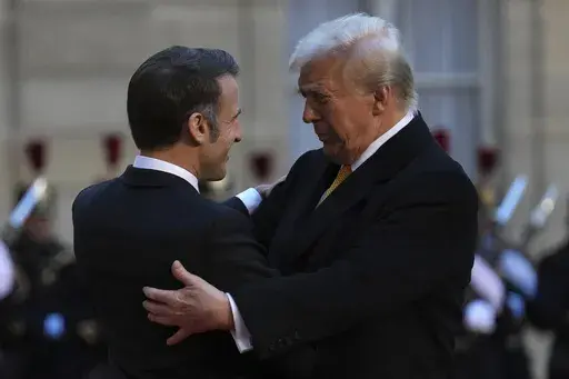 French President Emmanuel Macron, left, hugs President-elect Donald Trump as he arrives at the Elysee Palace, Saturday, Dec. 7, 2024 in Paris. (AP Photo/Aurelien Morissard)
