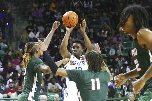 Baylor guard Adam Flagler scores over Mississippi Valley State guards Arecko Gipson, left, and Terry Collins (11) in the second half of an NCAA college basketball game, Monday, Nov. 7, 2022, in Waco, Texas. Baylor won 117-53. (AP Photo/Rod Aydelotte)
