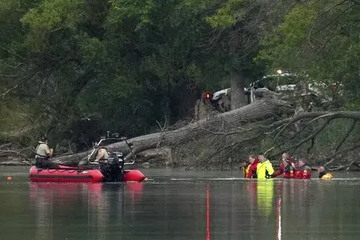 Teams in dry suits and Ramsey County Sheriff's deputies search for the bodies of a mother and her three children at Vadnais Lake, Saturday, July 2, 2022, in Vadnais Heights, Minn. The father of the children died at a different location hours earlier. (Anthony Souffle/Star Tribune via AP)
