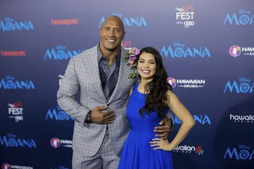 Actors Dwayne Johnson, left, and Auli'i Cravalho appear at the 2016 AFI Fest - "Moana" world premiere in Los Angeles on Nov. 14, 2016. Disney chief executive Bob Iger on Monday announced that a live-action “Moana” remake is in development in a call with investors. The production is in the early stages, but Dwayne Johnson is set to return as the demigod Maui. Cravalho, who voiced Moana in the original, is to be an executive producer on the live-action version. (Photo by Willy Sanjuan/Invision