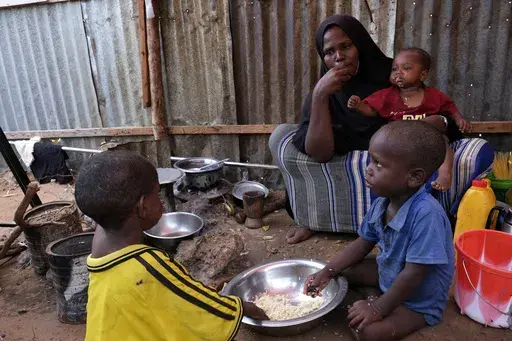 Hadiiq Abdulle Mohamed eats with her children as she speaks during an interview with The Associated Press at an internally displaced people camp on the outskirts of Mogadishu, Somalia, March 24, 2023. Children experienced the highest number of grave violations in conflicts ever verified by the United Nations in 2022, with the conflicts between Israeli and Palestinians and in Congo and Somalia putting the most in peril, the U.N. children's agency said Wednesday. (AP Photo/Farah Abdi Warsameh, Fil