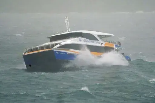 The Manly Ferry makes its way through heavy swells across Sydney Harbour, Australia, Sunday, July 3, 2022. A severe weather warning for heavy rainfall and strong winds has been issued for Sydney, as parts of NSW have received more than their monthly average rainfall within hours this weekend. (AP Photo/Mark Baker)