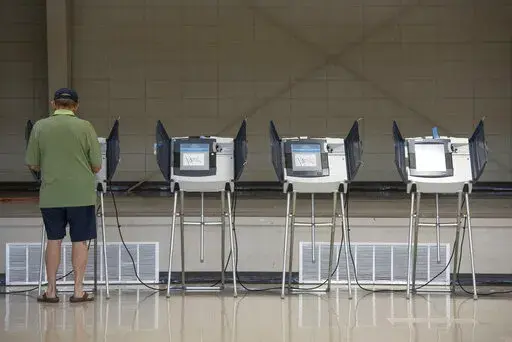 A voter uses an electronic voting machine to cast a ballot in the Mississippi primary election at a polling location in Jackson County, Miss., on June 7, 2022. Mississippi voters will be able to use their smartphones as voter identification in the November election, marking the first real test of a new statewide program that integrates technology into the voting process. (Hannah Ruhoff/The Sun Herald via AP, File)