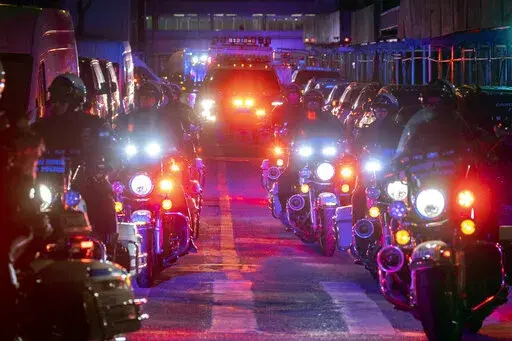 NYPD officers in motorcycles lead an ambulance carrying Officer Wilbert Mora as he is transferred from Harlem Hospital to NYU Langone hospital on Sunday, Jan. 23, 2022 in the Harlem neighborhood of New York. New York City Police Officer Jason Rivera was fatally shot Friday night while answering a call about an argument between a woman and her adult son. Mora and suspect Lashawn McNeil were wounded. (AP Photo/Yuki Iwamura)