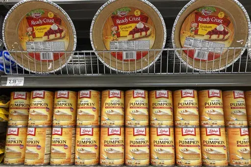 Canned pumpkin and graham cracker shell crusts are displayed at a Publix Supermarket, Tuesday, Nov. 16, 2021 in North Miami, Fla. Americans are bracing for a costly Thanksgiving this year, with double-digit percent increases in the price of turkey, potatoes, stuffing, canned pumpkin and other staples. (AP Photo/Marta Lavandier, File)
