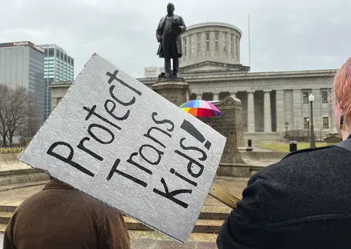 Demonstrators advocating for transgender rights and healthcare stand outside of the Ohio Statehouse on Jan. 24, 2024, in Columbus, Ohio. The rights of LGBTQ+ students will be protected by federal law and victims of campus sexual assault will gain new safeguards under rules finalized Friday, April19, 2024, by the Biden administration. Notably absent from Biden’s policy, however, is any mention of transgender athletes. (AP Photo/Patrick Orsagos, File)