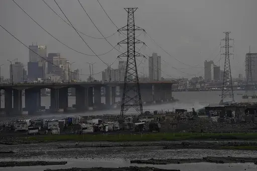 High tension power lines pass through Makoko slum in Lagos, Nigeria, Saturday, Aug. 20, 2022. From Zimbabwe, where many must work at night because i t's the only time there is power, to Nigeria where collapses of the grid are frequent, the reliable supply of electricity remains elusive across Africa. (AP Photo/Sunday Alamba/File)