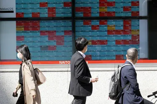 Pedestrians pass by an electronic stock board showing Japan's Nikkei 225 index at a securities firm, April 27, 2023, in Tokyo. Asian shares declined in muted trading Wednesday, May 10, 2023 as investors awaited an upcoming report on U.S. inflation, an important indicator for where interest rates and global growth might go in the coming months. (AP Photo/Eugene Hoshiko, File)
