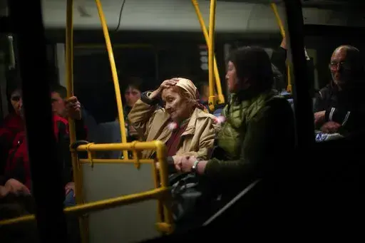 People who fled from Mariupol wait to leave after being processed upon their arrival at a reception center for displaced people in Zaporizhzhia, Ukraine, late Sunday, May 8, 2022. (AP Photo/Francisco Seco)