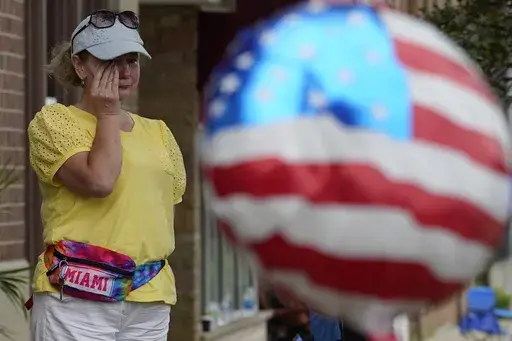 A woman wipes away tears after a mass shooting at an Independence Day parade that left seven people dead and dozens wounded, in the Chicago suburb Highland Park, July 4, 2022. Violence and mass shootings often surge in the summer months, especially around the Fourth of July, historically one of the deadliest days each year. (AP Photo/Nam Y. Huh, File)