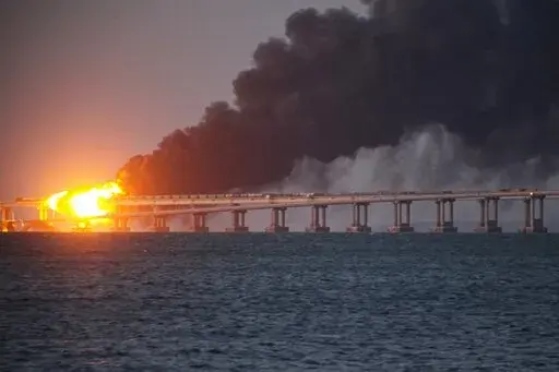 Flame and smoke rise from the Crimean Bridge connecting Russian mainland and the Crimean peninsula over the Kerch Strait, in Kerch, Crimea, Oct. 8, 2022. Russian authorities say a truck bomb has caused a fire and the partial collapse of a bridge linking Russia-annexed Crimea with Russia. Three people have been killed. The bridge is a key supply artery for Moscow's faltering war effort in southern Ukraine. (AP Photo/File)