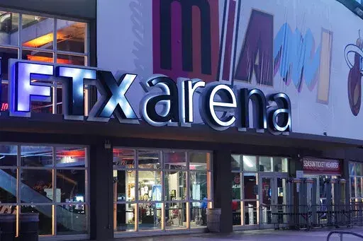 Signage for the FTX Arena, where the Miami Heat basketball team plays, is illuminated Saturday, Nov. 12, 2022, in Miami. Collapsed cryptocurrency trading firm FTX confirmed there was “unauthorized access” to its accounts, hours after the company filed for Chapter 11 bankruptcy protection Friday, Nov. 11.    (AP Photo/Marta Lavandier)