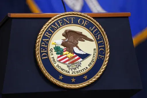 The seal for the United States Department of Justice is displayed on a podium before a news conference at the Justice Department in Washington, Thursday, April 13, 2023. (AP Photo/Evan Vucci, File)