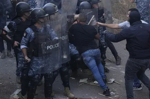 Lebanese-Armenian protesters clash with riot police near the Azerbaijani Embassy, during a protest to denounce the Azerbaijani military offensive that recaptured Nagorno-Karabakh from the separatist Armenian authorities in the enclave, in Ain Aar, east of Beirut, Lebanon, Thursday, Sept. 28, 2023. A 24-hour Azerbaijani blitz last week forced Armenian separatist authorities to sit down for talks on Nagorno-Karabakh's "reintegration" into Azerbaijan. (AP Photo/Hussein Malla)