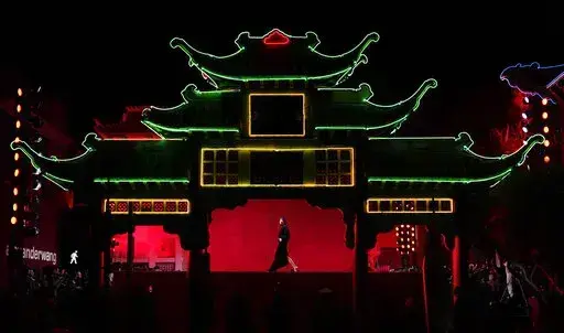A model is framed in the East Gate at Old Chinatown Plaza as she walks the runway at fashion designer Alexander Wang's "Fortune City" runway show and party celebrating Asian-American culture, Tuesday, April 19, 2022, in Los Angeles. (AP Photo/Chris Pizzello)