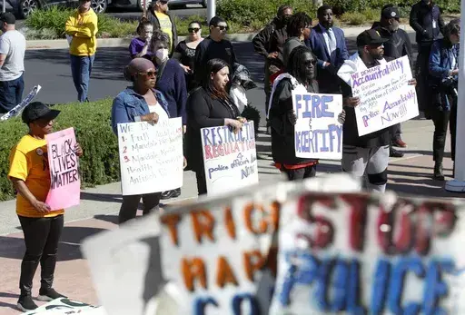 Community members listen to speakers during a rally at Antioch police headquarters in Antioch, Calif., on April 18, 2023. Racist police text messages containing slurs and images of gorillas will take center stage in a San Francisco Bay Area courtroom on Friday, July 21, 2023, as a judge weighs whether the messages violated a state law designed to stamp out racism in the criminal court system. (Jane Tyska/Bay Area News Group via AP)