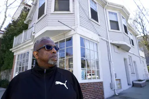 Terrell Osborne, of Providence, R.I., stands for a portrait, Monday, April 11, 2022, in front of an antique shop, that was a general store in the early 1960s, in what was then known as the Lippitt Hill neighborhood, in Providence. As a child growing up in Providence in the late 1950s and 1960s, he watched as huge swaths of his 30-acre neighborhood of Lippitt Hill, a center of Black life at the foot of the stately homes of the city's elite East Side, were taken by eminent domain for redevelopment