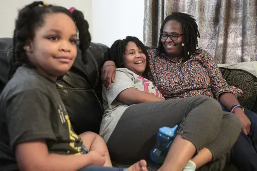 Deleah Payne, 12, center, spends time with her mother Delisa, right, and 6-year-old sister Delynn, left, as they watch movie clips on their living room television in Evansville, Ind., Tuesday evening, Aug. 27, 2019. Deleah and Delynn were both diagnosed with autism. For the first time, autism is being diagnosed more frequently in Black and Hispanic children than in white kids in the U.S., the Centers for Disease Control and Prevention said Thursday, March 23, 2023. (Sam Owens/Evansville Courier 