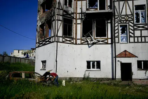 A man checks his car destroyed by attacks in Mostyshche, on the outskirts of Kyiv, Ukraine, Monday, June 6, 2022. (AP Photo/Natacha Pisarenko)