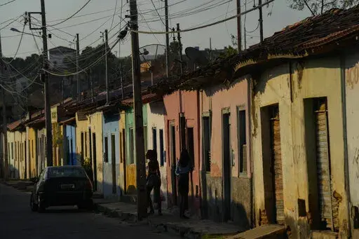 Residents stand on the sidewalk in Aracuai, Brazil, Oct. 11, 2022. Araçuai is part of the Jequitinhonha Valley in northern Minas Gerais state, bordering the poor northeast region that is a stronghold for former President Luiz Inacio Lula da Silva, who is running for president again. Gaining traction in Minas Gerais is especially important to incumbent Jair Bolsonaro, as the state has the second-largest population in the country. The two presidential candidates will face each other in a runoff O