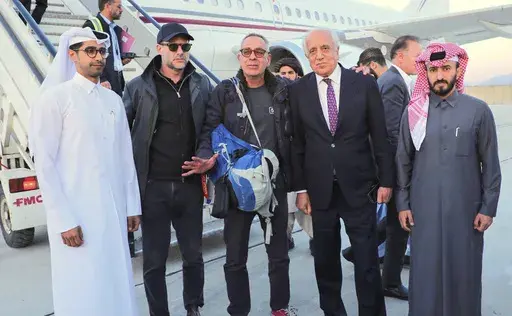 In this handout photo released by Qatar Ministry of Foreign Affairs, George Glezmann, center, poses with Adam Boehler, second left, and Zalmay Khalilzad, second right, and Qatari diplomats in Kabul, Afghanistan, Thursday, March 20, 2025, before departing to Doha, Qatar. (Qatar Ministry of Foreign Affairs via AP)