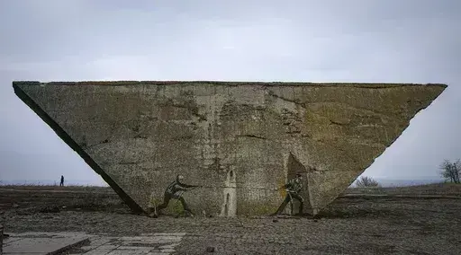 Ukrainian and Russian soldiers are depicted in a tug-of-war game on a memorial in Izium, Kharkiv region, Ukraine, Sunday, March 17, 2024. (AP Photo/Efrem Lukatsky)