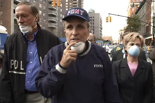 FILE — New York Mayor Rudolph Giuliani, center, leads New York Gov. George Pataki, left, and Sen. Hillary Rodham Clinton, D-N.Y., on a tour of the site of the World Trade Center disaster, Sept. 12, 2001. Giuliani, once warmly regarded as "America's Mayor" in the wake of the 9/11 attacks, and who first rose to prominence as a federal prosecutor going after mobsters with a then-novel approach to racketeering cases, has seen his reputation tumble and his liberty threatened in defense of Donald Tr