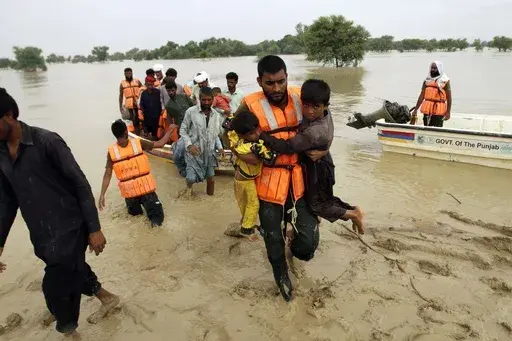 Army troops evacuate people from a flood-hit area in Rajanpur, district of Punjab, Pakistan, Aug. 27, 2022. The flooding in Pakistan killed at least 1,700 people, destroyed millions of homes, wiped out swathes of farmland, and caused billions of dollars in economic losses. (AP Photo/Asim Tanveer, File)
