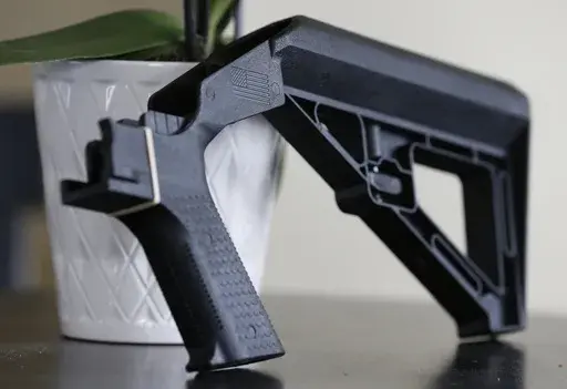 A bump stock is displayed in Harrisonburg, Va., on March 15, 2019. The Supreme Court will hear a challenge Wednesday, Feb. 28, to a Trump-era ban on bump stocks, a gun accessory used in a Las Vegas massacre that was the deadliest mass shooting in modern U.S. history. (AP Photo/Steve Helber, File)