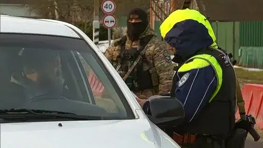 In this image taken from footage provided by the RU-RTR Russian television on Friday, March 3, 2023, a Russian policeman checks documents of drivers not far from the border between Russia and Ukraine in Russia. Russia has declared that a group of saboteurs from Ukraine crossed into its territory and attacked border villages, a raid marking an escalation of the war that dragged into a second year. On Friday, the Russian leader had a video call with members of his Security Council, saying in openi