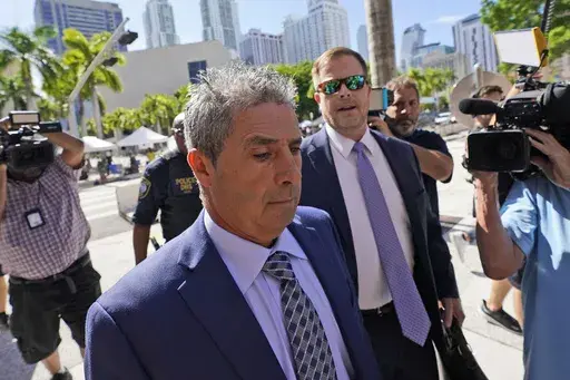 Carlos De Oliveira, center, an employee of Donald Trump's Mar-a-Lago estate, arrives for a court appearance with attorney John Irving, at the James Lawrence King Federal Justice Building, Monday, July 31, 2023, in Miami. De Oliveira, Mar-a-Lago's property manager, was added last week to the indictment with Trump and the former president's valet, Walt Nauta, in the federal case alleging a plot to illegally keep top-secret records at Trump's Florida estate and thwart government efforts to retrieve