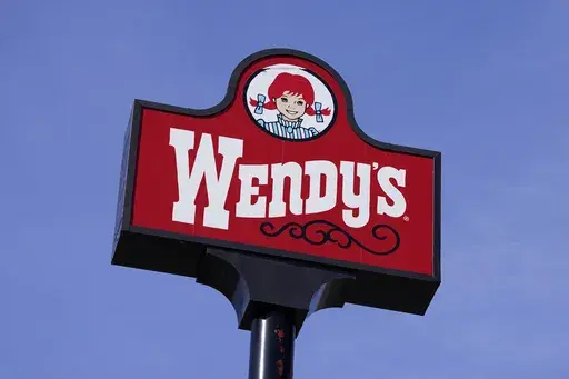 A sign stands over a Wendy's restaurant, Feb. 25, 2021, in Des Moines, Iowa. Wendy’s says that it has no plans to increase prices during the busiest times at its restaurants, Wednesday, Feb. 28, 2024. The burger chain clarified its stance on how it will approach pricing after various media reports said that the company was looking to test having the prices of its menu items fluctuate throughout the day based on demand. (AP Photo/Charlie Neibergall, File)