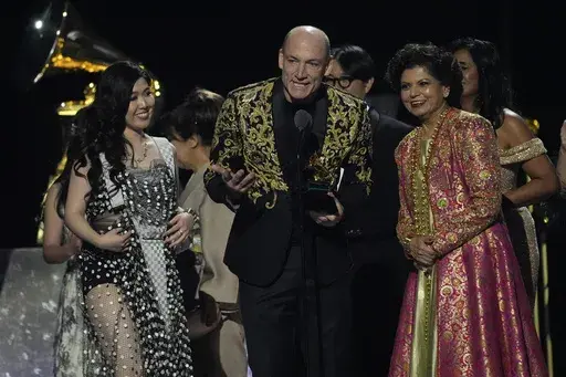 Eru Matsumoto, from left, Wouter Kellerman, and Chandrika Tandon accept the award for best new age, ambient, or chant album for "Triveni" during the 67th annual Grammy Awards on Sunday, Feb. 2, 2025, in Los Angeles. (AP Photo/Chris Pizzello)