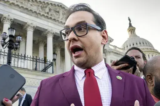 Rep. George Santos, R-N.Y., speaks to reporters outside the Capitol, in Washington, May 17, 2023. Santos, 34, has spent weeks fighting efforts by news outlets to unseal the names of the two people who co-signed the $500,000 bond, which enabled his pretrial release as he awaits federal charges of fraud, money laundering and theft of public funds. (AP Photo/J. Scott Applewhite, File)
